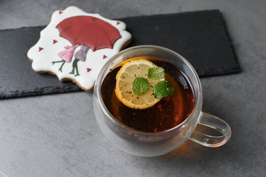 Glass cup of black tea with lemon, with a beautiful, painted gingerbread