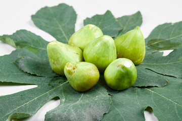 Ripe green figs with leaves on white background