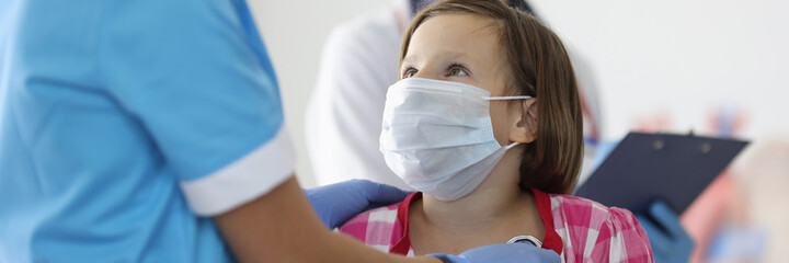 Doctor listens to girl breathing with stethoscope at reception in clinic. Symptoms of pneumonia and...