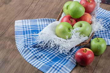 Fresh apples in a metallic basket on a piece of white burlap