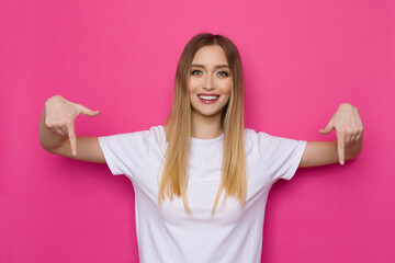 Casual Young Woman Is Pointing Down And Smiling