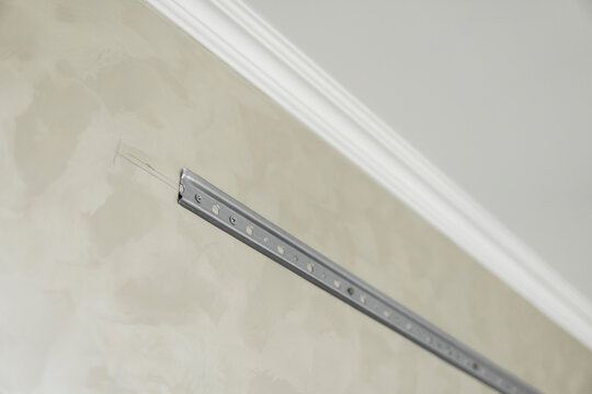 Close-up of stainless steel mounting rail for mounting kitchen cabinets on a wall.