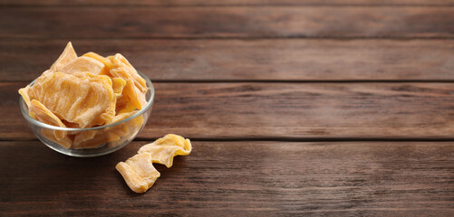 Delicious dried jackfruit slices on wooden table. Space for text