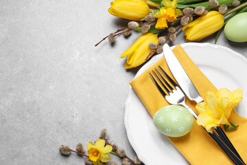 Festive Easter table setting with eggs on grey background, flat lay. Space for text