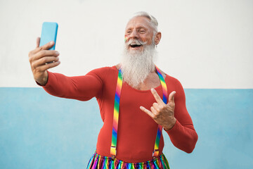 Senior gay man using mobile phone during lgbt pride protest - Focus on face