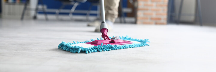 Professional cleaning services for complex cleaning of premises. Man wash floor Mop with damp cloth...