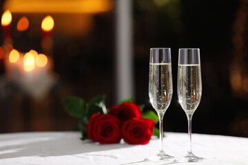 Glasses of champagne on table in restaurant, space for text. Romantic dinner