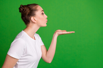 Profile photo of lovely lady hold palm blow air kiss look empty space wear white t-shirt isolated...