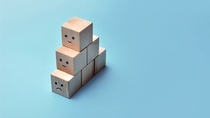 Wooden cubes with drawings of various human emotions: Sadness, calmness, joy. 