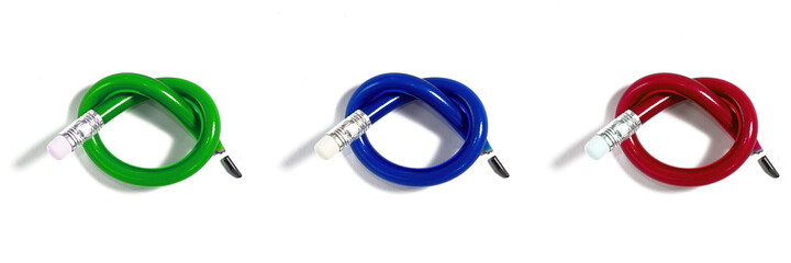 Set of isolated multicolored knotted broken pencils on the white paper. Unusual office supply and stationery