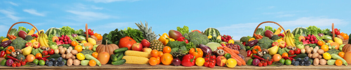 Fototapeta na wymiar Assortment of fresh organic fruits and vegetables on wooden table outdoors. Banner design