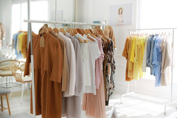 Stylish women's clothes on rack in modern boutique