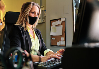 a secretary with protective mask working- new normal
