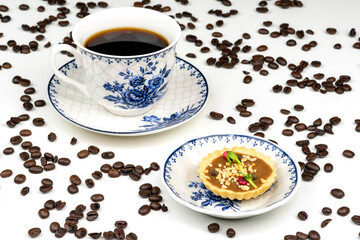 Cup of a coffee and tartlet on a plate