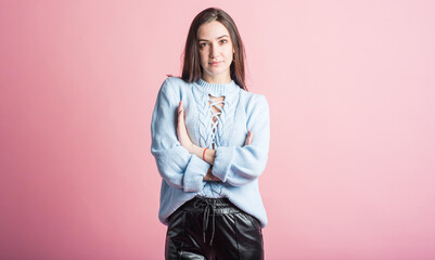 Portrait of a brunette girl on a pink background who is happy and smiling