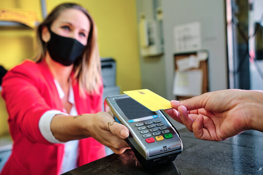 Woman With Protective Mask Using Credit Card To Pay Contactless