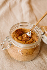 Panela brown sugar background. Close up view of raw cane sugar in a jar.	