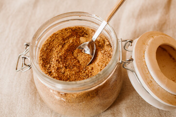 Panela brown sugar background. Close up view of raw cane sugar in a jar.	