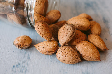 Almonds in a jar on wooden rustic table as background. Close up view.	