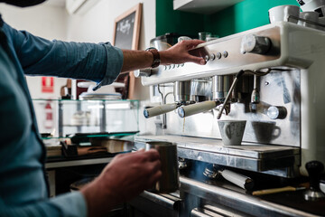 unrecognizable person preparing coffee in cafeteria