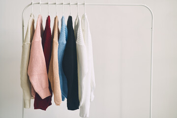 multicolored women's woolen sweaters on hangers. Sale in a fashion store