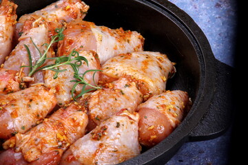 Marinated raw chicken legs on black pan. Uncooked marinated chicken. Marinated chicken drumsticks