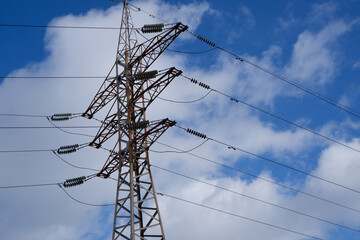High voltage power line. View of the metal support of the power transmission line against the...