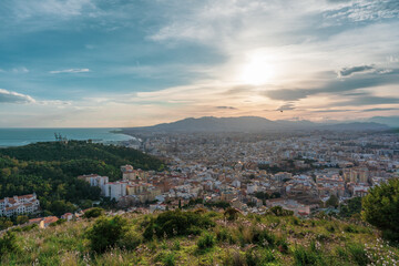 Fototapeta na wymiar beautiful views from the top of the hill over the city of Malaga with the mountains, the sea and the cloudy sky in the background at sunset