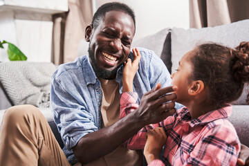 Dad sitting at the floor and joking with his daughter