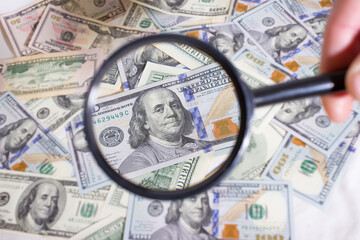 Magnifying glass on the background of bundle dollars - texture, background