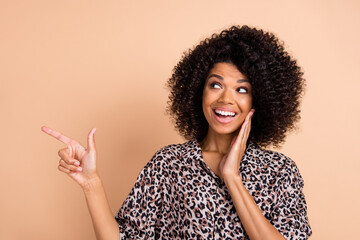 Photo of young afro woman happy smile look point finger empty space ad promo advise choose isolated...