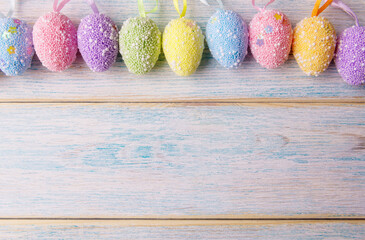 Decorative Easter eggs over blue wooden background with copy space. Easter holiday greeting