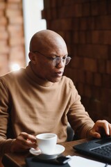 African american business man with laptop in a cafe