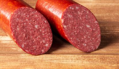  Sliced salami sausage on cutting board closeup. Food preparation idea before the holiday