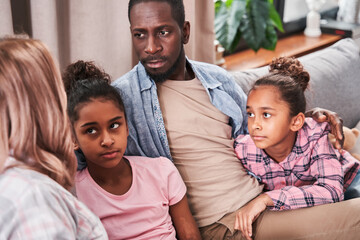 Family sitting on the sofa and looking at each other