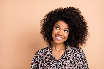 Photo portrait of smiling curly woman curious dreaming looking blank space isolated pastel beige color background © deagreez