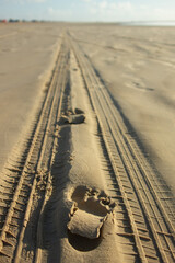 Tire tracks and footprints at the beach sand in Brazil