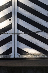 Fototapeta premium schwarz-weiss diagonal gestreifte tür detail mit kette