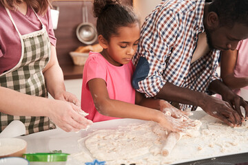 Happy parents cooking and baking cookies with small children