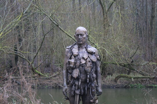 Norwich Norfolk East Anglia / England United Kingdom - February 18 2021: The Man Of Stones Sculpture By Laurence Edwards, Artwork In Place By University Broad Water Among Trees Outdoors In Landscape