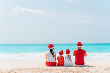 Happy family with two kids in Santa Hat on summer vacation