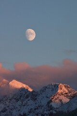Moon rising above the Karwendel mountains (Schoettelkarspitze). The last sun sunbeams tinting the...