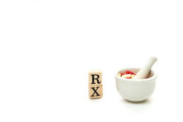 Hospital, clinic, healthcare and medical concept. RX with Mortar and Pestal with red and yellow pills isolated on white background. Mortar and RX symbol using as pharmacy concept.