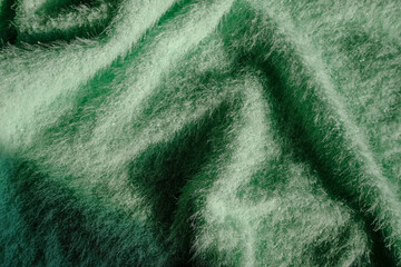 Green fluffy soft textile background with drapers. Top view. Copy space. fashion, style, elegance concept