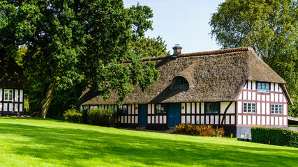 Fototapeta na wymiar An old farm house now belonging to Trapholt (art museum) in Kolding, Denmark. Its thatched roof and half-timber walls makes it a solid place to live.