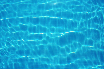 Blue water in swimming pool with sun reflection