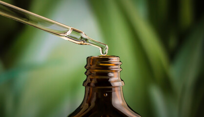 A drop of liquid from a pipette on a green background.