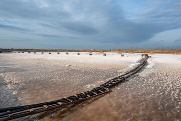 Machine gathering salt on Pomorie salt lake in Bulgaria. Harvesting sea salt	