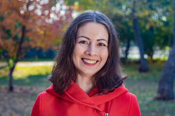 Beautiful young smiling woman in red coat