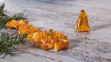 Beautiful sparkling transparent yellow amber beads on a gray background.  Amber necklace, amber stone, Slavic culture. 